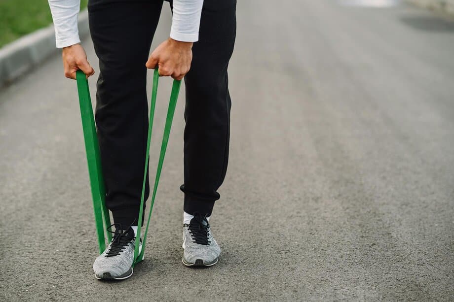 Man traint thuis met weerstandsbanden - effectief alternatief voor sportschool voor drukke vaders