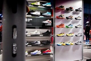 Man kiest hardloopschoenen in sportwinkel in 2026