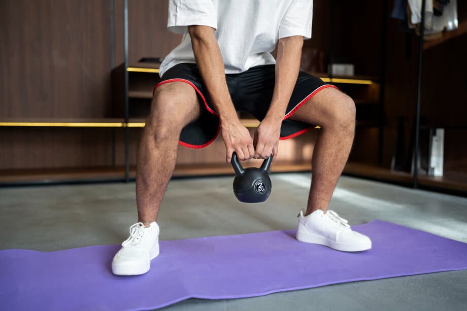 Man traint thuis met kettlebell - effectieve thuistraining voor drukke vaders
